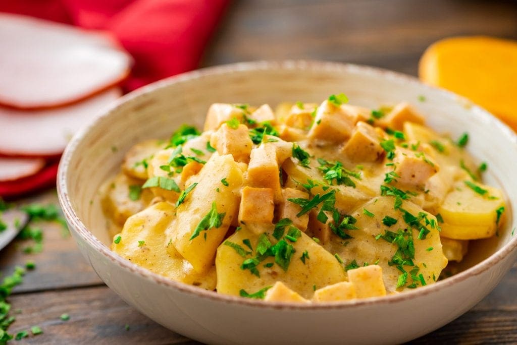 Bowl with scalloped potatoes in it and garnished with parsley