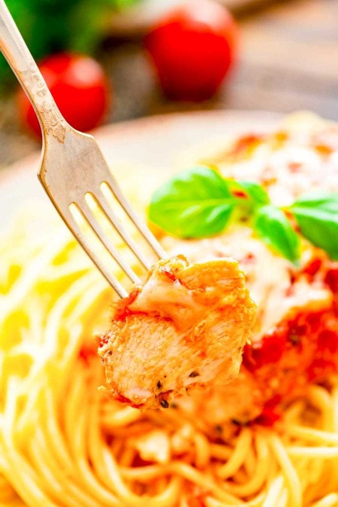 Piece of crock pot chicken Parmesan on fork