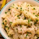 Overhead close up of a bowl of shrimp pasta with parsley garnish