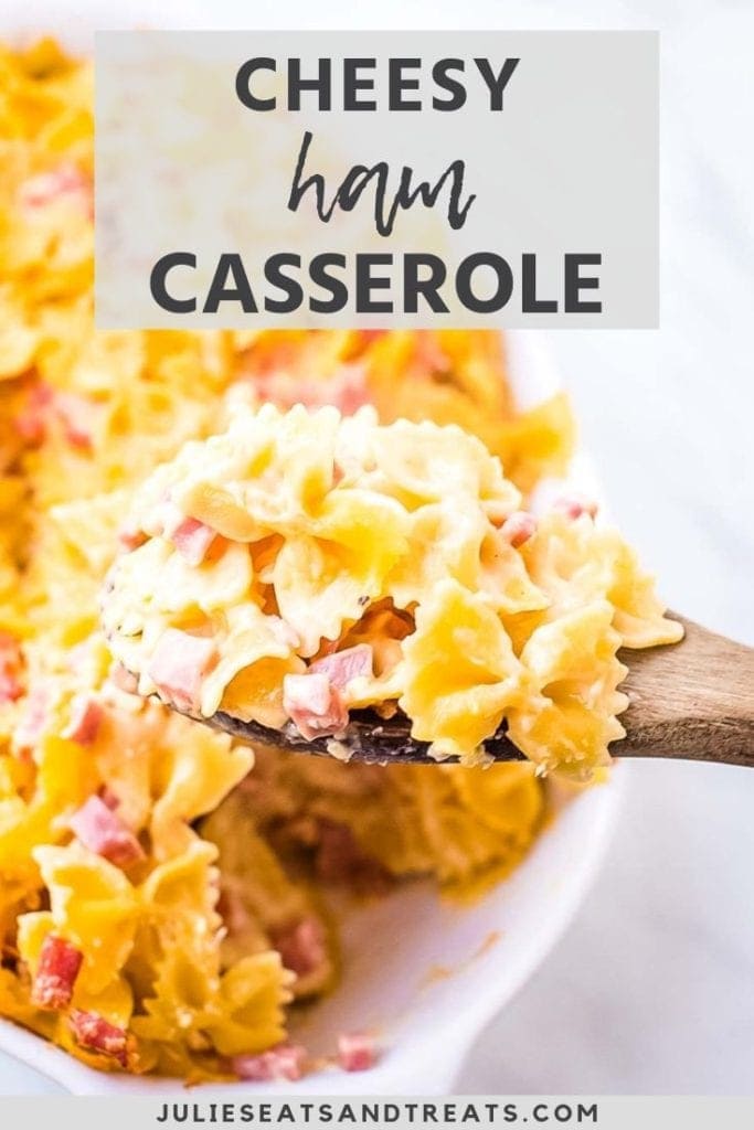 cheesy ham casserole on a wooden spoon over a baking dish of casserole
