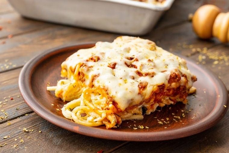 Square slice of Baked Spaghetti on wooden plate