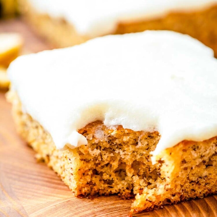 Frosted Banana Bars on wood cutting board