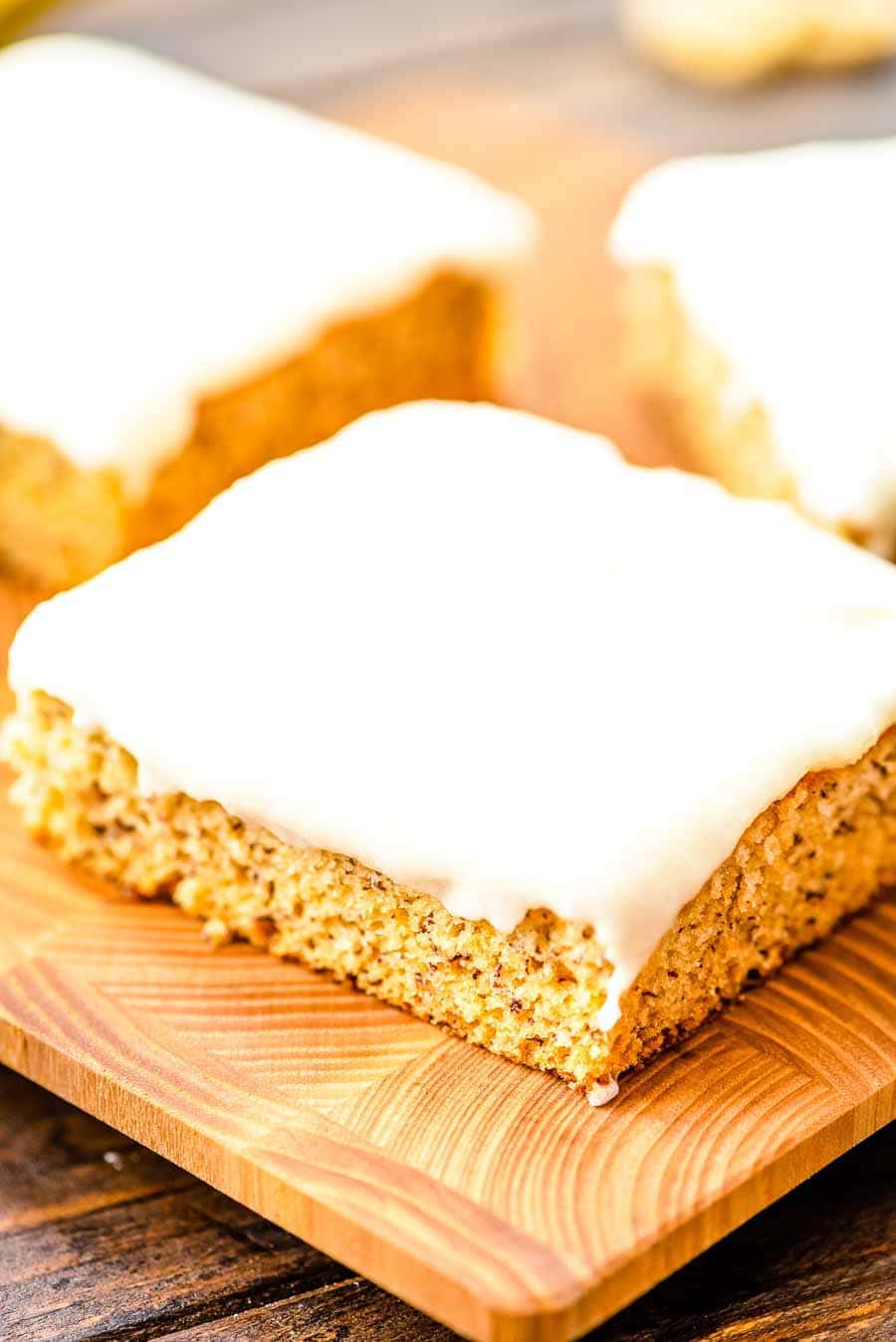 Square Slices of Frosted Banana Bars on cutting board