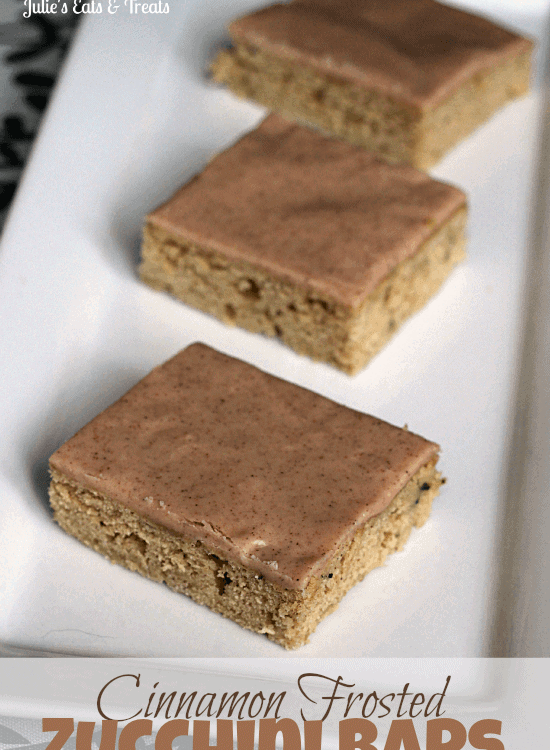 Three cinnamon frosted zucchini bars on a white plate