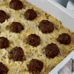 Meatball hash brown bake in a white casserole dish
