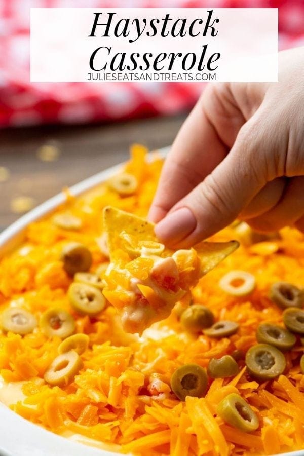 Hand dipping a chip into haystack casserole