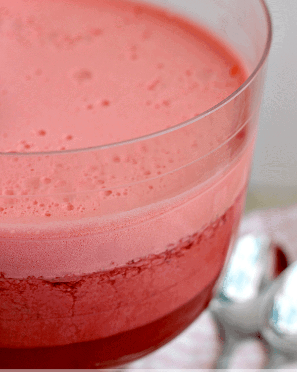 Tall glass bowl of layered strawberry salad