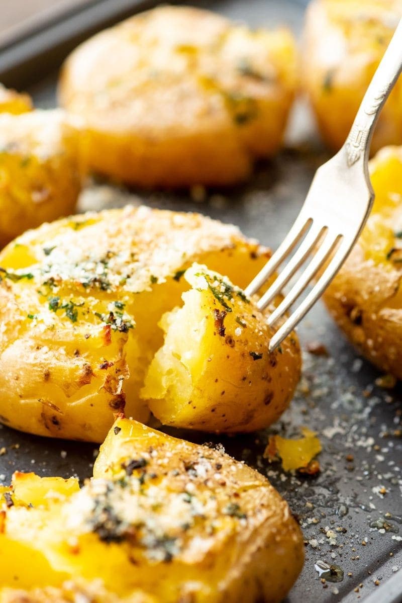 Smashed Potatoes on sheet pan with fork