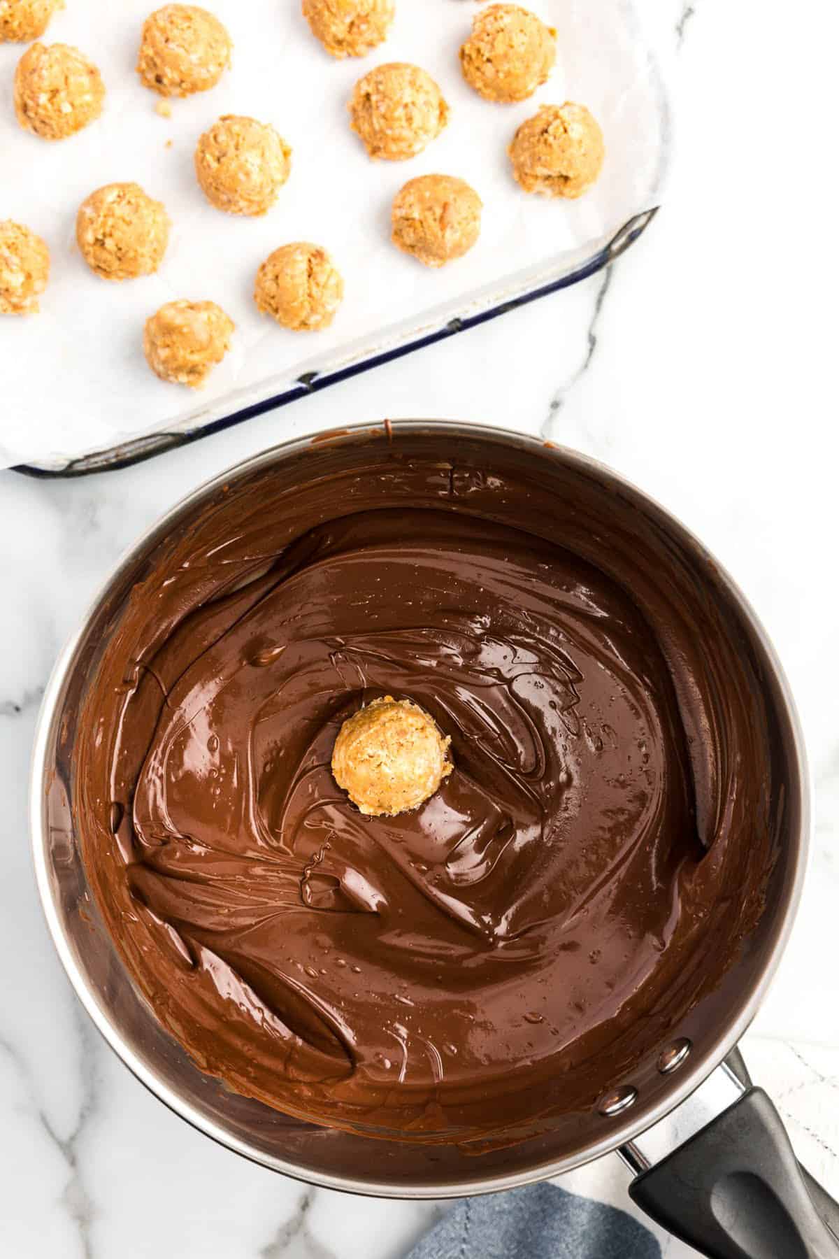 Dipping peanut butter ball in saucepan