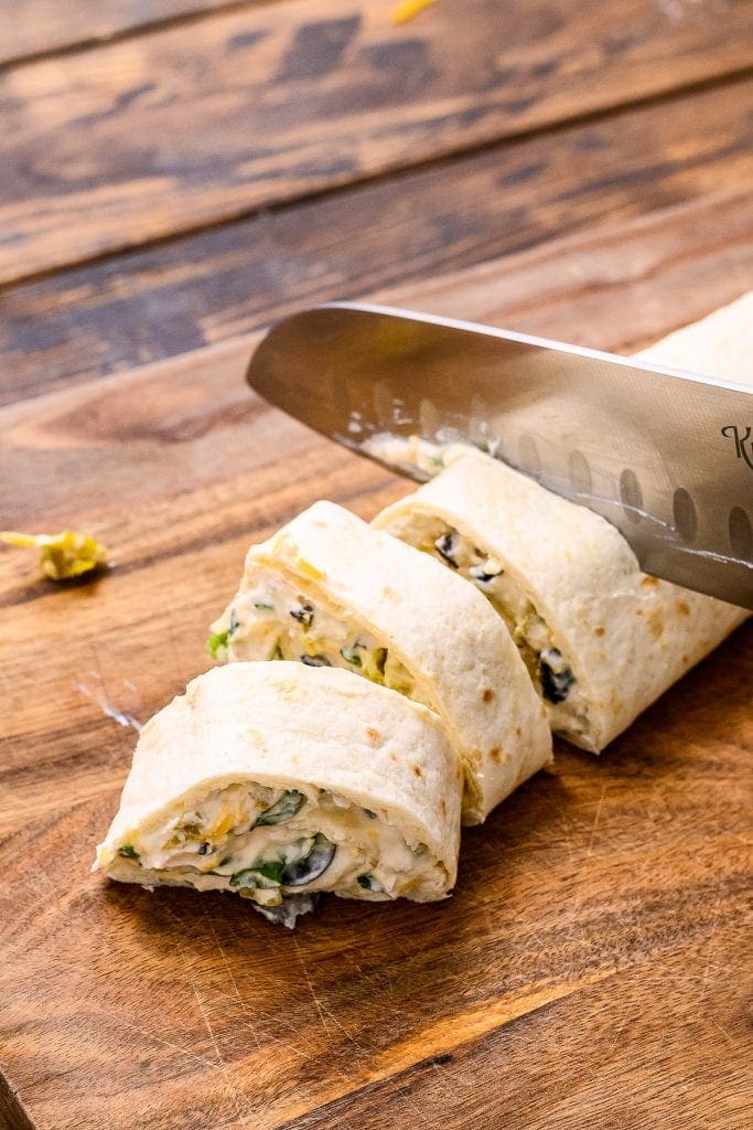 Knife cutting the tortilla pinwheels into slices