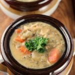 Two brown bowls of crock pot cheesy chicken wild rice soup