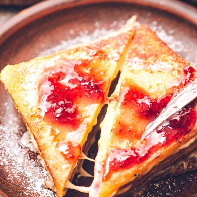 Monte Cristo sandwich Cut at a diagonal topped with jelly and powdered sugar