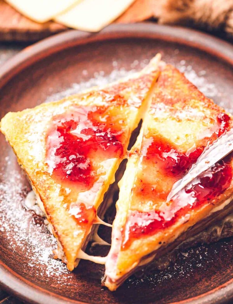Monte Cristo sandwich Cut at a diagonal topped with jelly and powdered sugar