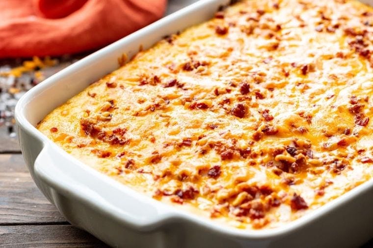 Close up image of a white baking dish with twice baked potato casserole in it.