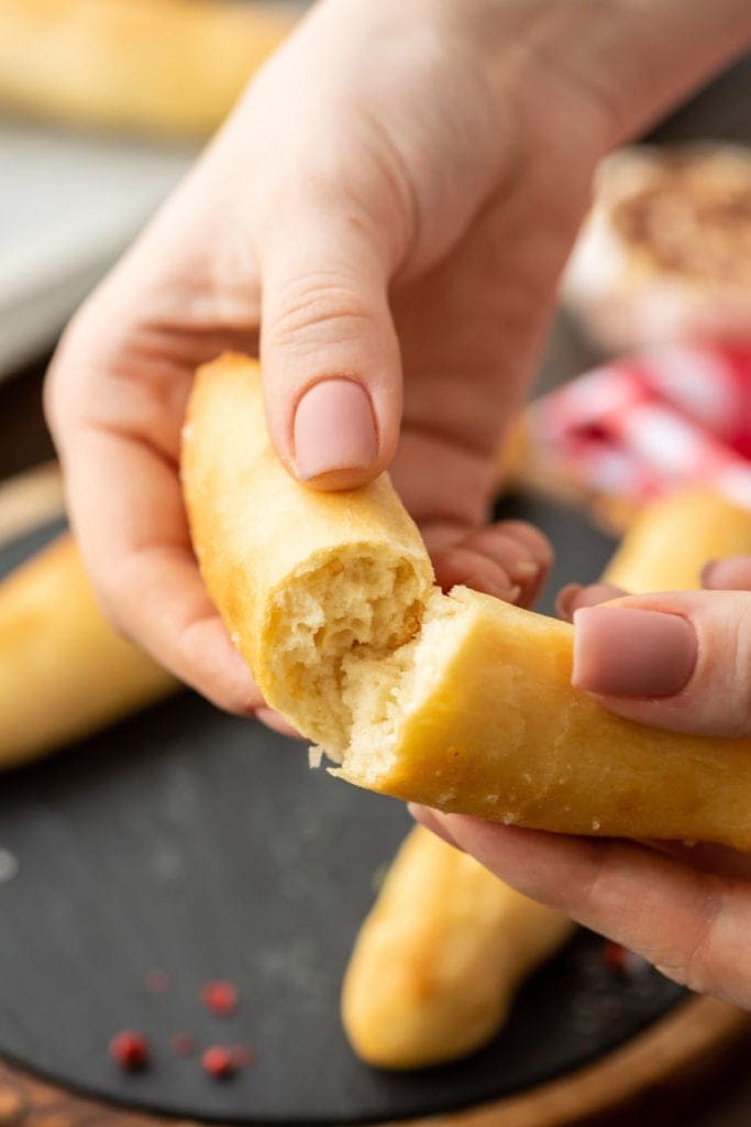 Pair of hands breaking apart breadstick