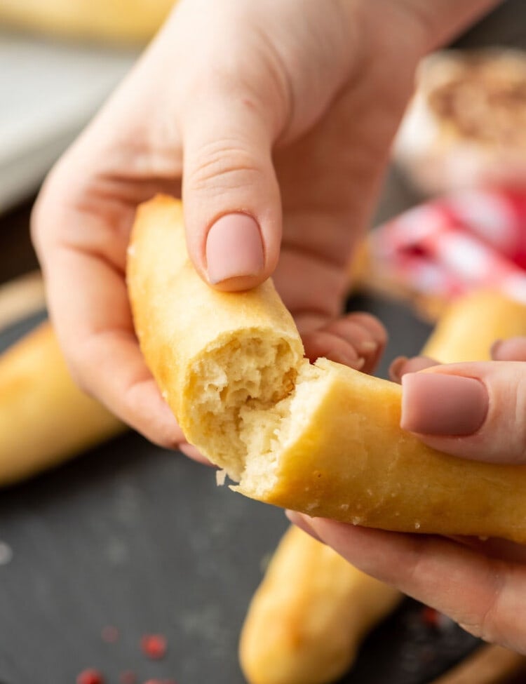 hands breaking breadstick in half