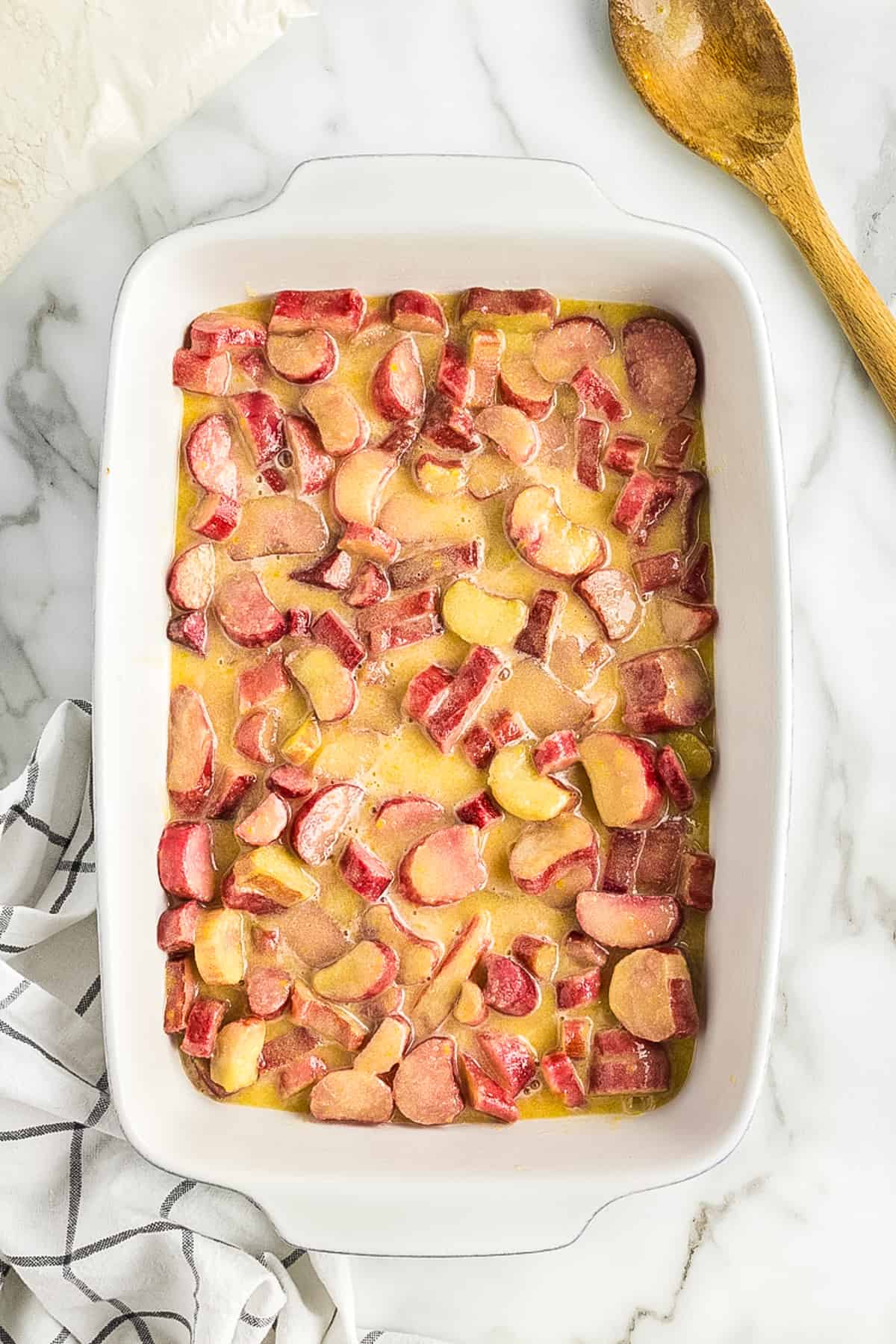 White baking dish with rhubarb dessert filling