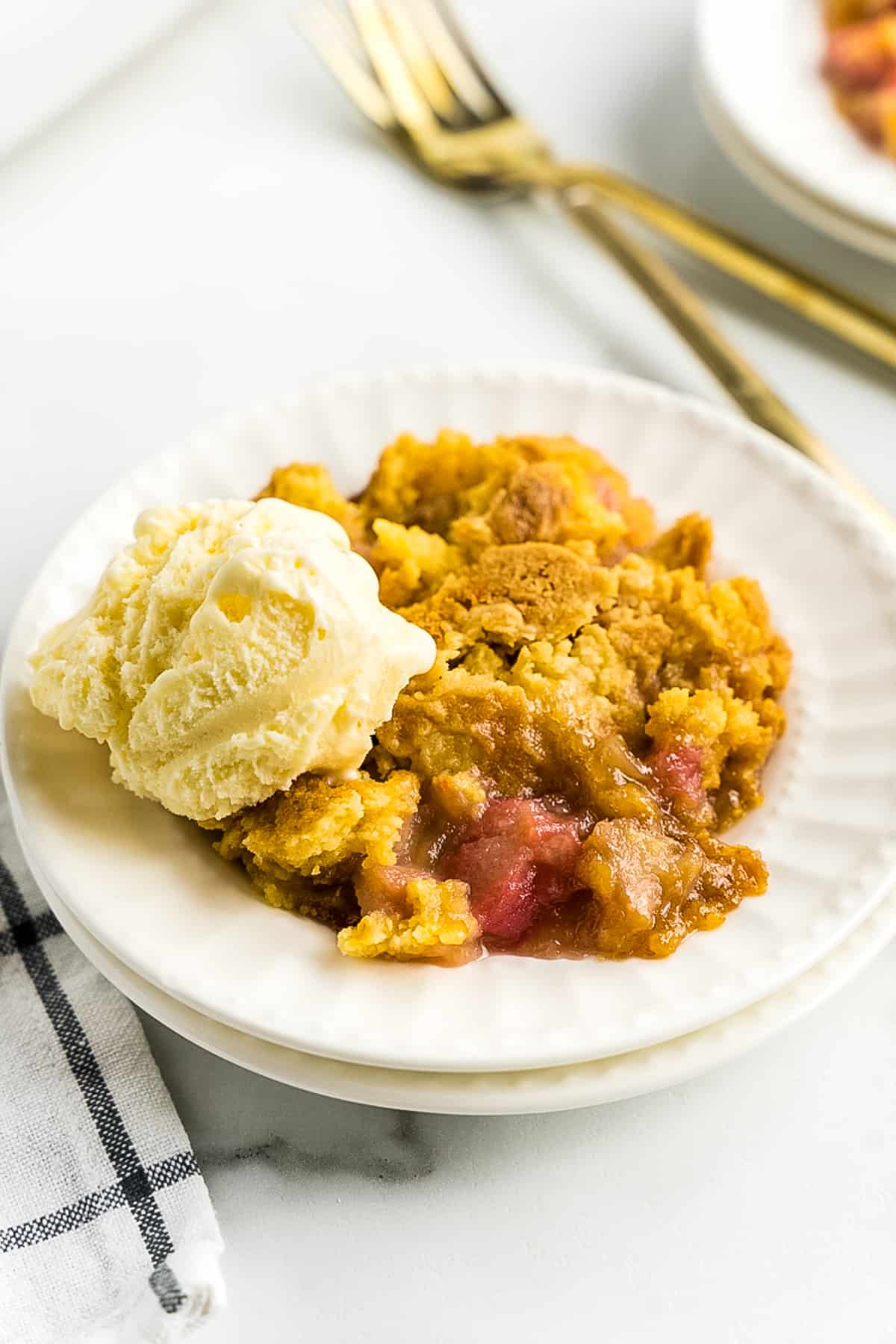 White plate with ice cream and Rhubarb Dump Cake