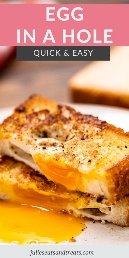 A piece of toast with an egg in the center cut in half with yolk running onto a plate