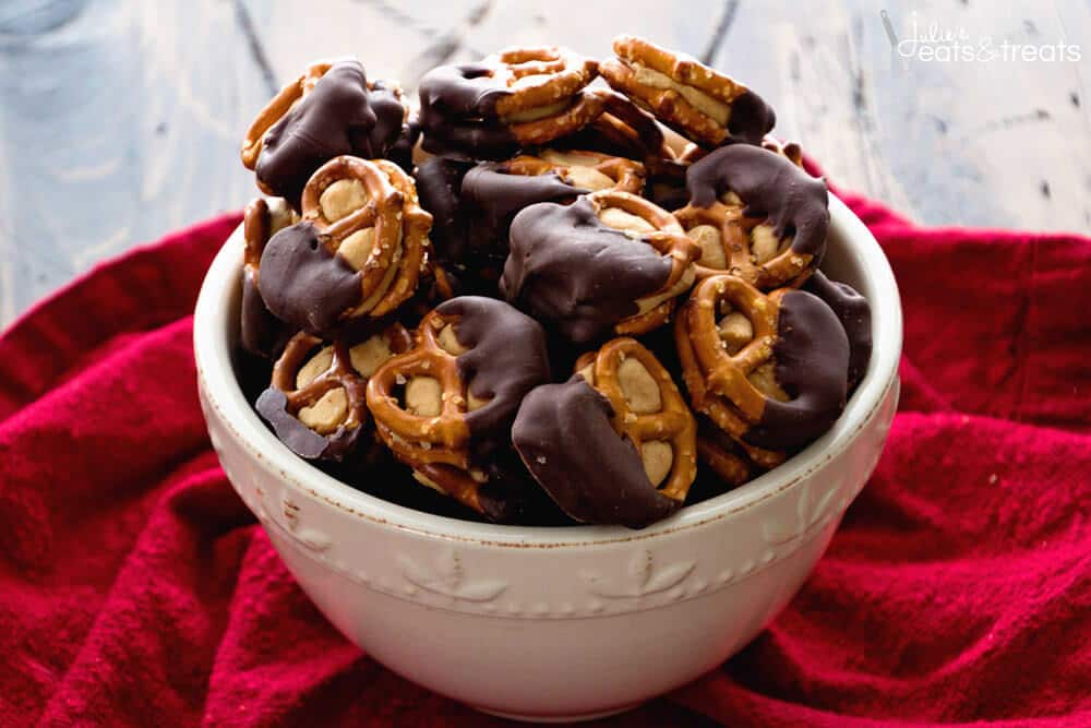 A bowl of chocolate covered peanut butter pretzels on a red napkin.