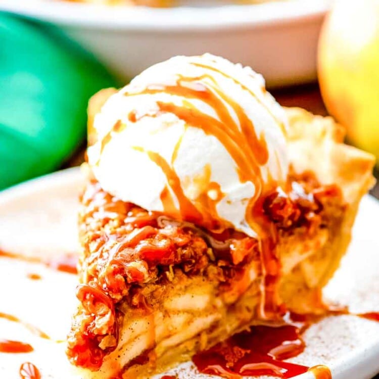 Slice of Apple Pie with crumb topping and ice cream on a plate