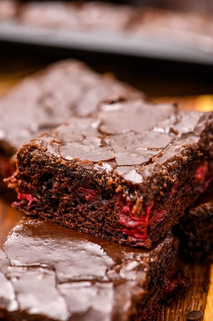 Cut chocolate cherry bar with frosting stacked on top of two other bars