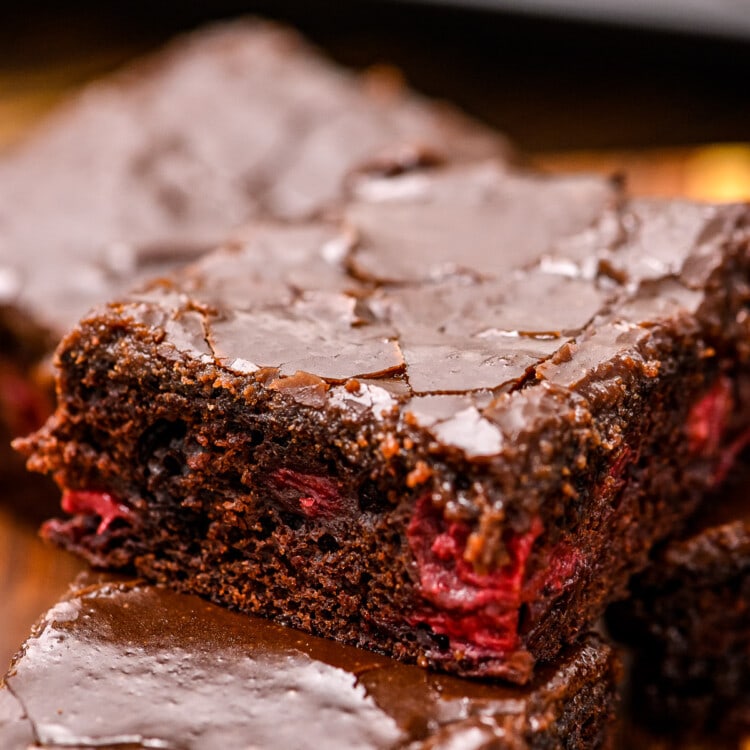 Cut chocolate cherry bar with frosting stacked on top of two other bars