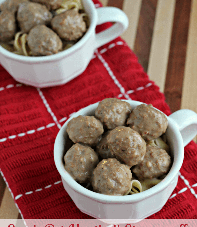 Two white mugs of crock pot meatball stroganoff over pasta sitting on a red towel