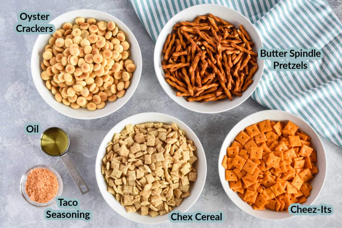 Overhead image with the ingredients to make taco chex mix cheez-its, pretzels, oyster crackers, chex cereal, taco seasoning, oil