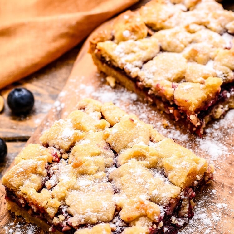 Prepared bars on small wooden cutting board dusted with powdered sugar