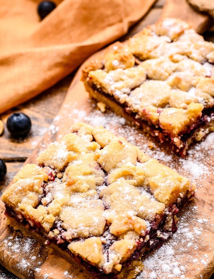 Prepared bars on small wooden cutting board dusted with powdered sugar