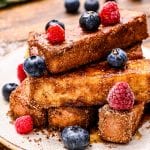 Plate with french toast sticks on it and blueberries and rasperries