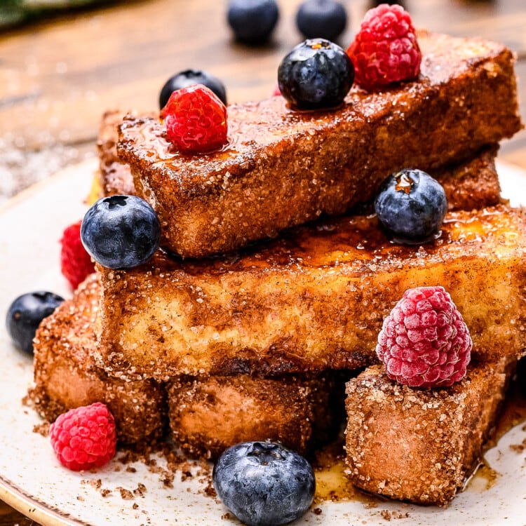 Plate with french toast sticks on it and blueberries and rasperries