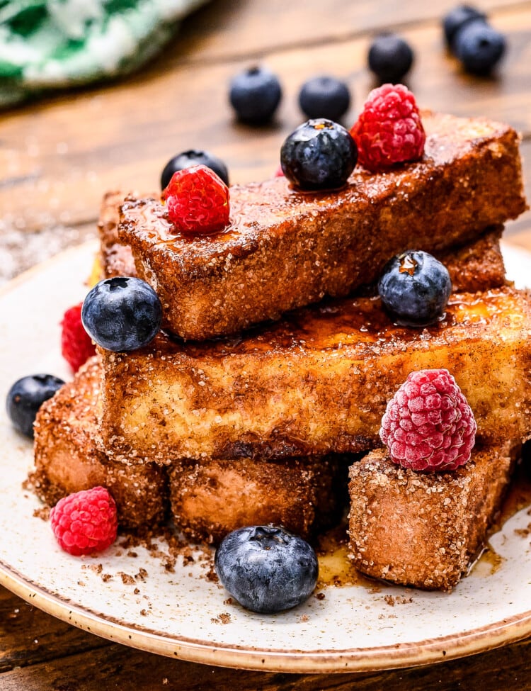 Plate with french toast sticks on it and blueberries and rasperries