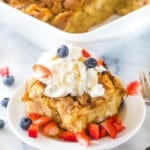 Overnight French Toast Casserole on plate with whipped cream and berries