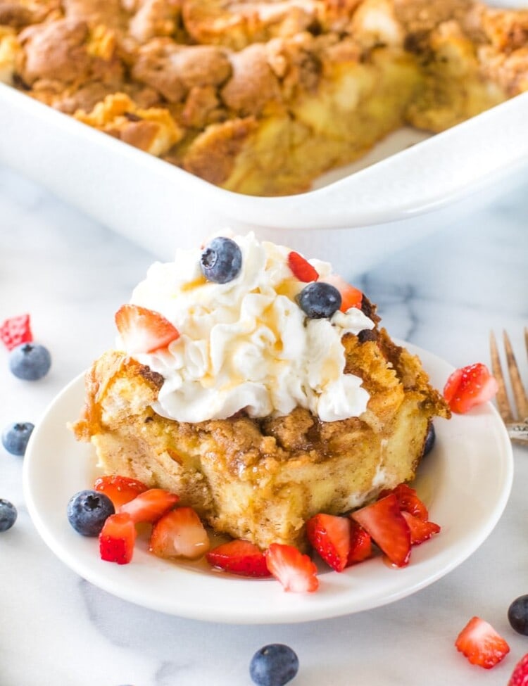 Overnight French Toast Casserole on plate with whipped cream and berries