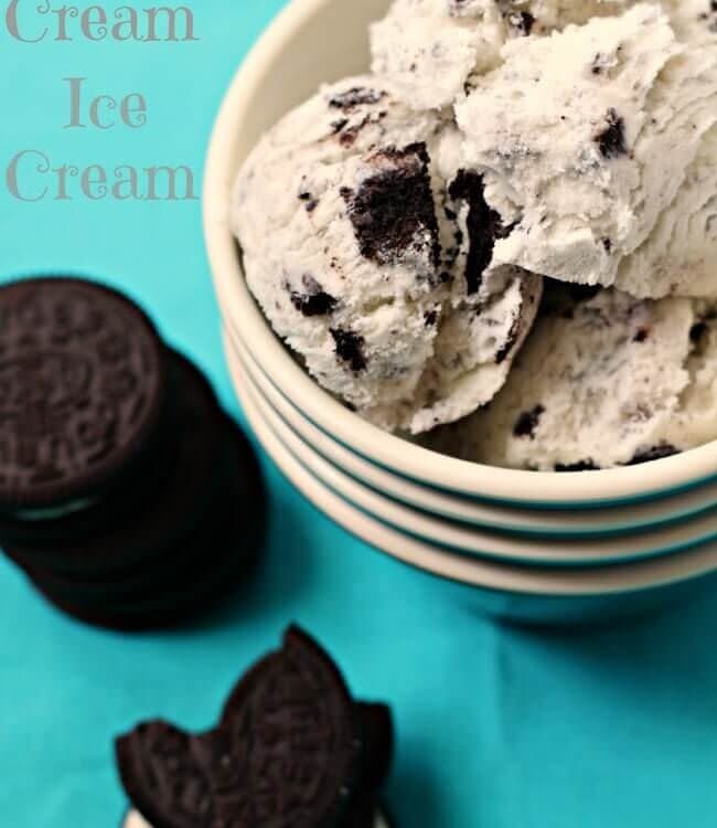 Four bowls stacked with the top full of cookies and cream ice cream sitting on a blue cloth napkin with Oreos