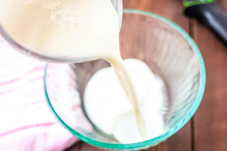 cream being poured into a glass bowl