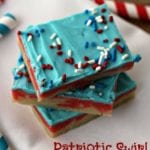 Three Patriotic swirl sugar cookie bars stacked on a white cloth napkin