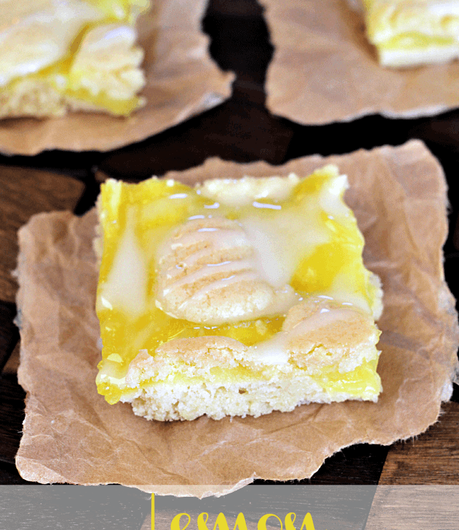 Three lemon pie bars on pieces of parchment paper