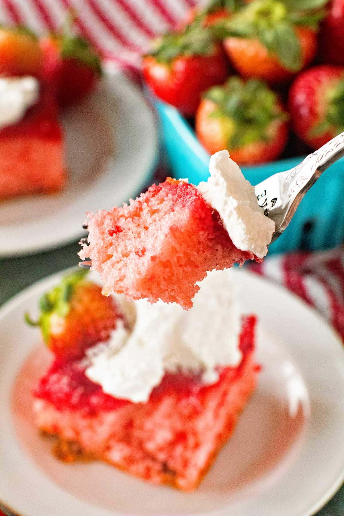 Fork with a piece of strawberry cake and cool whip on it