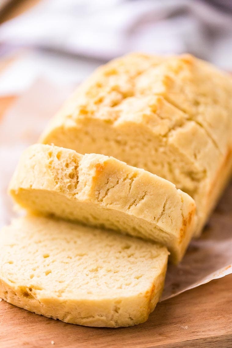 Loaf of sliced Beer Bread sitting on a wood cutting board