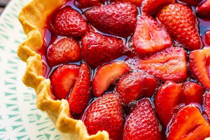 Closeup of Strawberry Pie on a plate showing strawberries in pie shell with jello filling