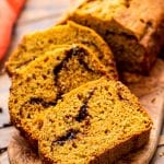 Pumpkin Zucchini Bread Recipe slice don a wooden cutting board.