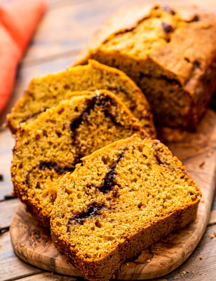 Pumpkin Zucchini Bread Recipe slice don a wooden cutting board.