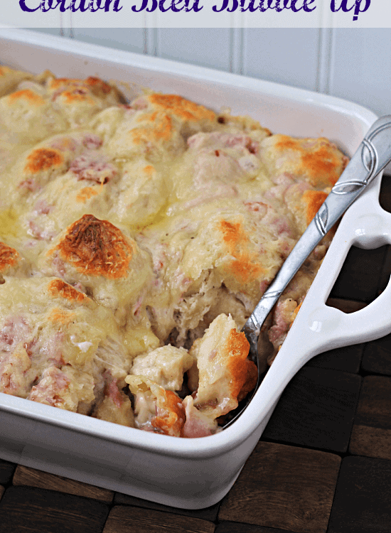 White baking dish of cordon bleu bubble up with a spoon