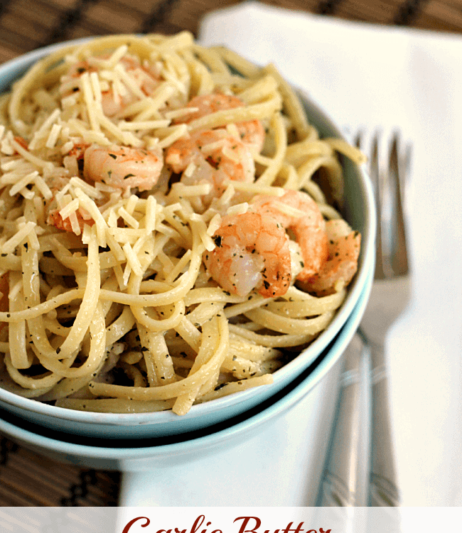 Two blue bowls stacked on a white napkin with the top one full of garlic butter shrimp scampi