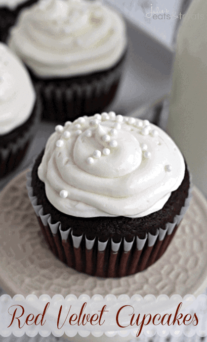 Red velvet cupcake with icing and pearl sprinkles on a small white stand