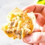 Hand holding a sausage and green pepper wonton