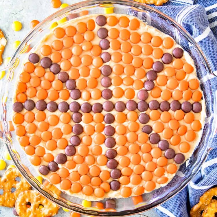 Overhead image of peanut butter dip in a clear glass pie plate with candies on top in the shape of a basket ball